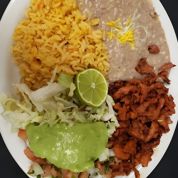 Albertano's Mexican plate with rice, refried beans, carne asada, guacamole, pico de gallo, and lime.